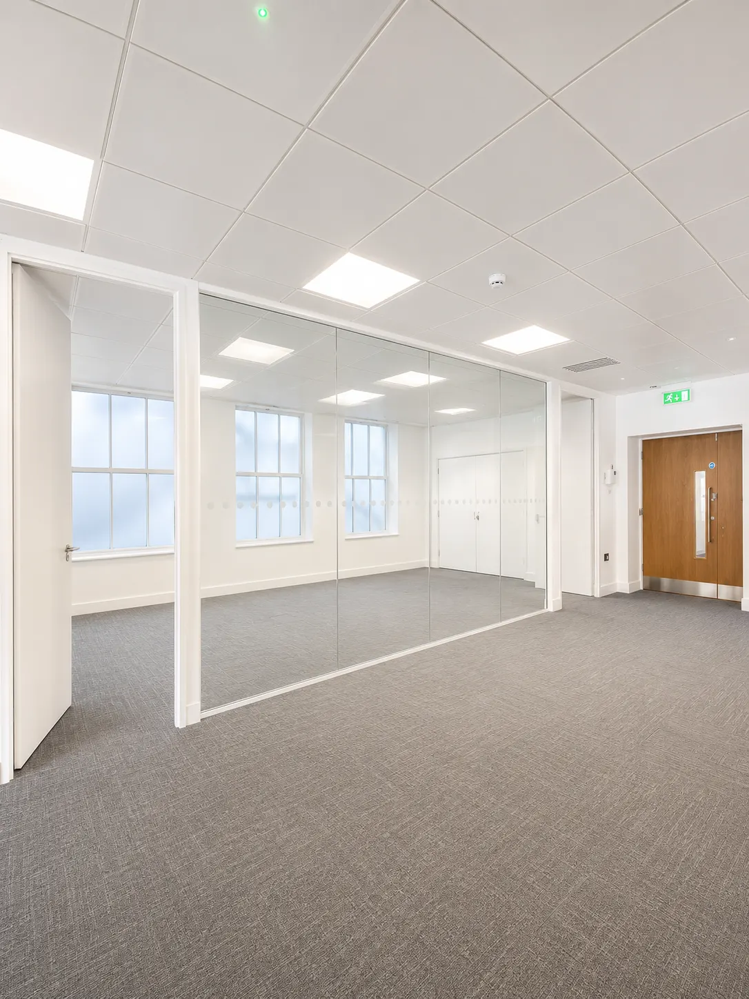 First floor at 16-18 New Bridge Street today, glass partitioned meeting room with mirrored wall